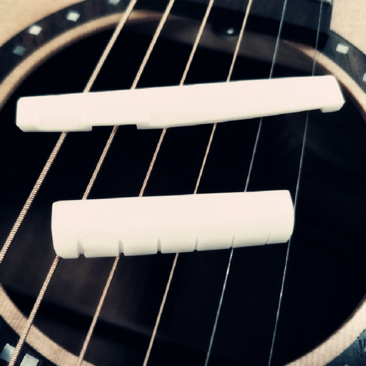 Guitar string bridge pillow set with two white ox bone pieces on guitar strings