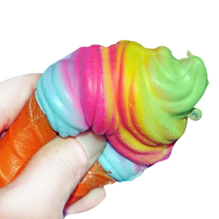 Rainbow ice cream cone squishy toy held in hand, orange cone with green-pink-blue swirl top.