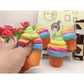 Two rainbow ice cream cone squishy toys on display, orange cones with pink-blue-green swirl tops.