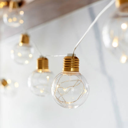 Copper wire LED string lights with clear G45 globe bulbs and gold caps, single bulb view