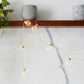 Copper wire LED string lights with warm clear globe bulbs and gold caps, close-up