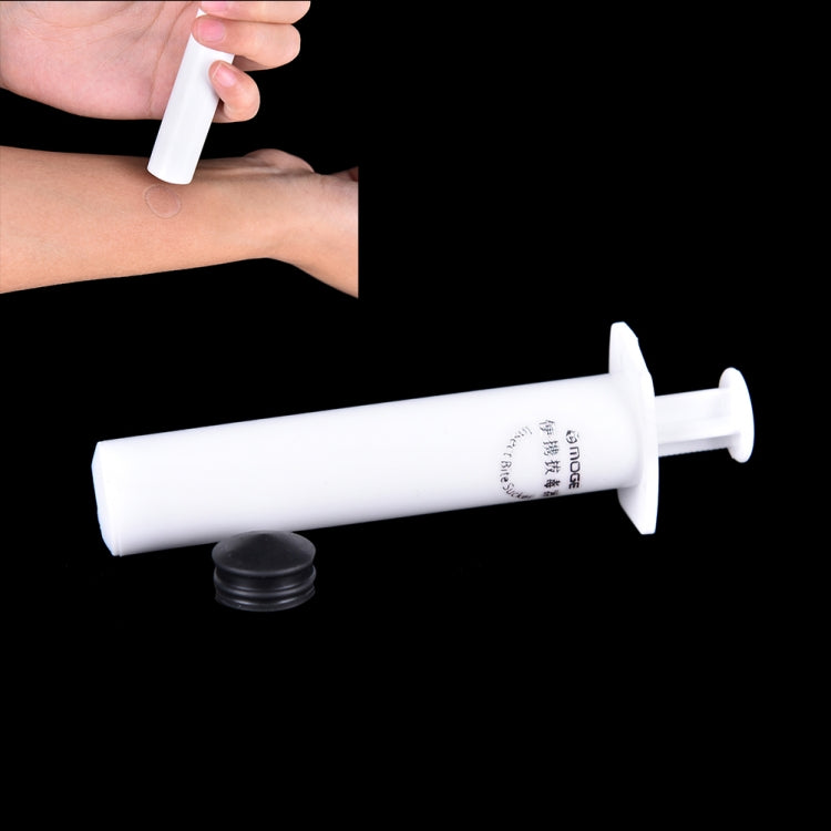 Venom extractor syringe being applied to an arm, with small black cap nearby
