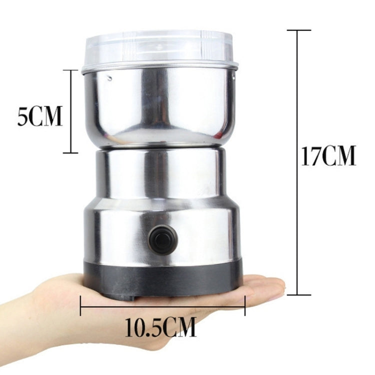 Compact stainless electric grinder with clear lid and black base, shown next to hand