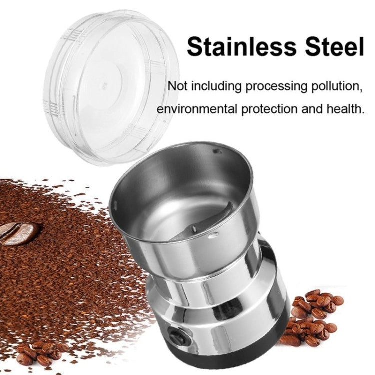 Stainless electric coffee grinder with open clear lid and visible coffee grounds in cup