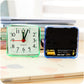 Square quartz alarm clock set: green front dial and blue open battery compartment
