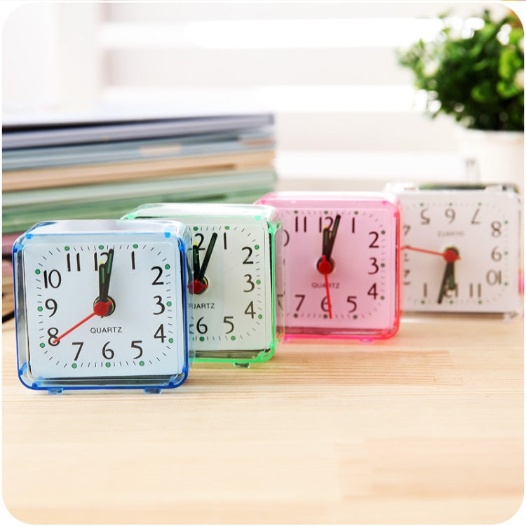 Square quartz alarm clocks with transparent cases in blue, green, and pink on desk