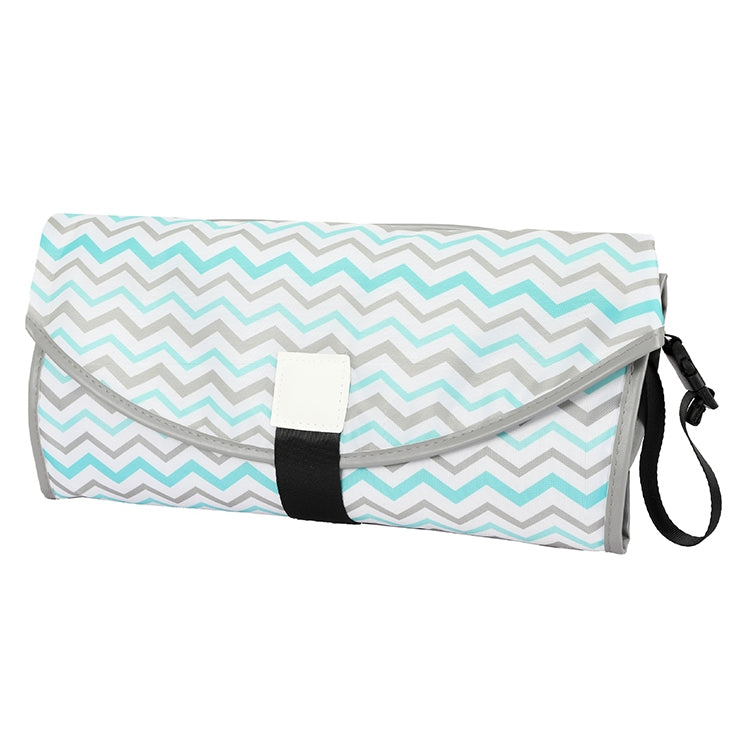 Folding waterproof changing pad with teal zigzag pattern, gray edge trim, and black carry strap.