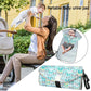 Portable waterproof changing pad with teal leaf-pattern cover and black side strap.