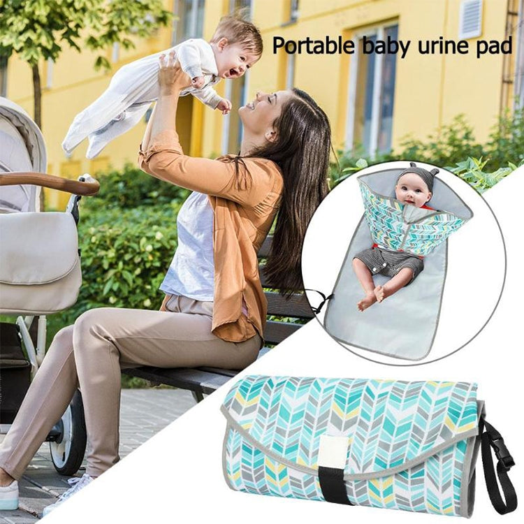Portable waterproof changing pad with teal leaf-pattern cover and black side strap.