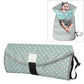 Folding waterproof changing pad, light gray-green with white dot pattern and carry strap.