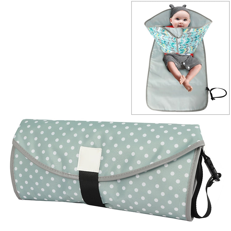 Folding waterproof changing pad, light gray-green with white dot pattern and carry strap.