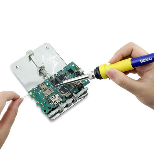 Soldering iron being used on a circuit board with metal tip and yellow handle