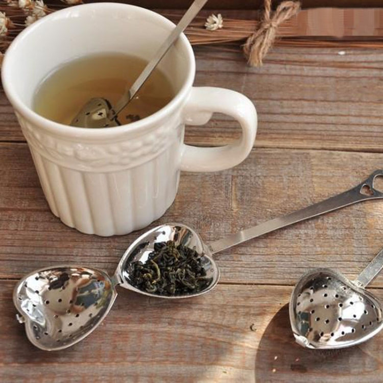 Set of two heart-shaped stainless steel tea infuser spoons on a wooden surface
