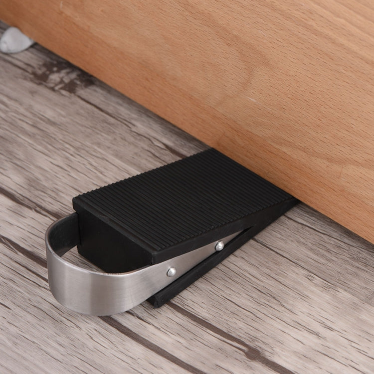 Door anti-theft pad installed on floor: black ridged block with metal band