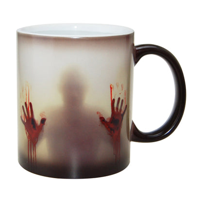 Color-changing ceramic coffee mug with red handprint graphic, dark band, black handle