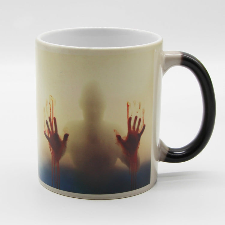 Color-changing ceramic coffee mug with red handprint graphic and light background, black handle
