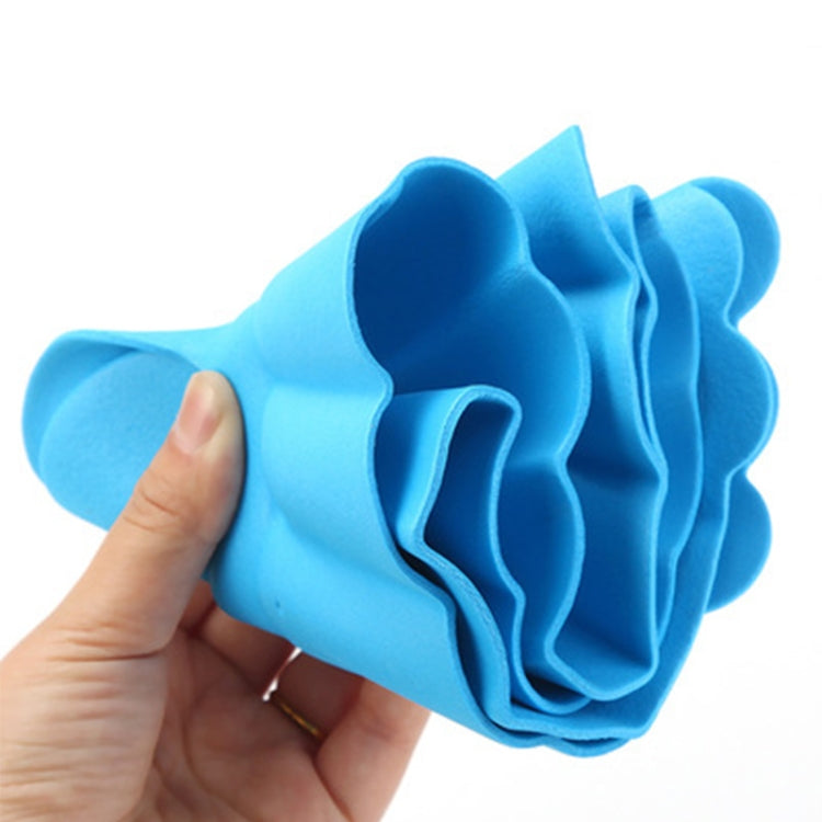 Blue kids shower cap with ruffled brim and earflap-style openings, held in hand