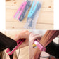 Mini hair straightener with pink plates in use on brown hair