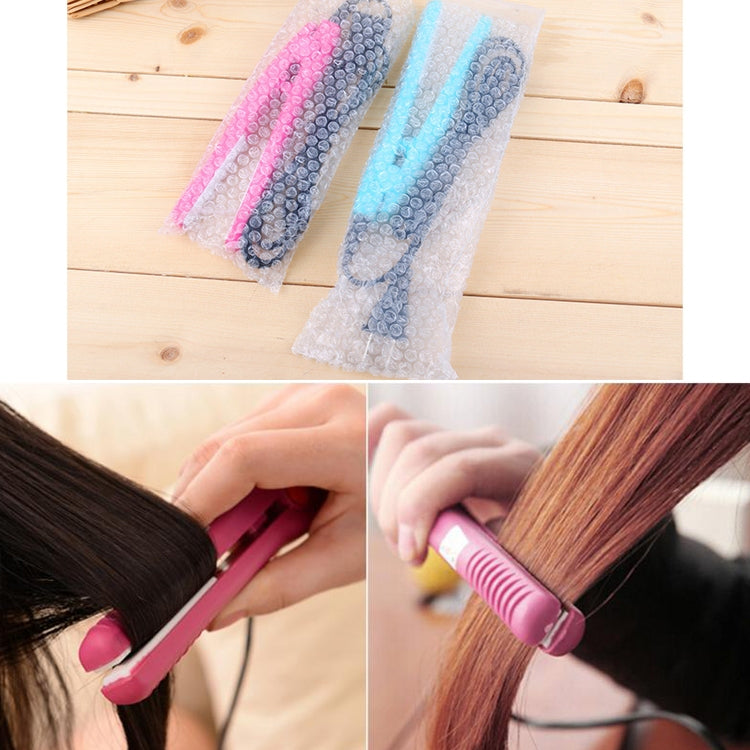 Mini hair straightener with pink plates in use on brown hair