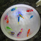 Electric fish shower toy set floating in a round basin with colorful fish