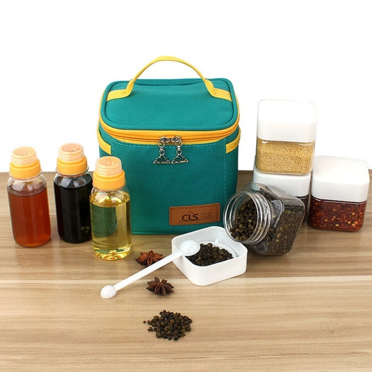 Teal insulated seasoning bag with bottles, spice jars, and small measuring spoon on table.