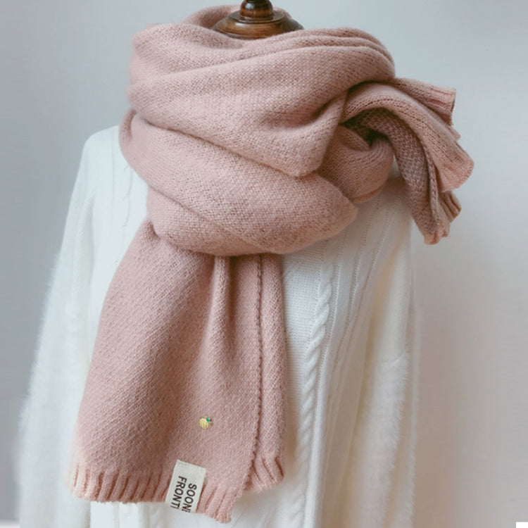 Pink thick knit scarf loosely wrapped with ribbed ends and small woven brand label