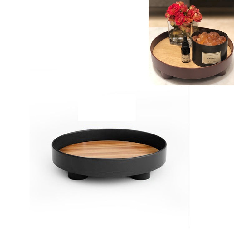 Round black desktop storage tray with beige insert and three raised feet