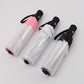 Transparent folding umbrellas in pink and white, folded with black strap handles
