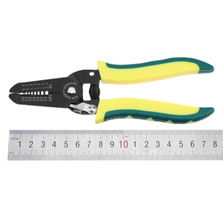 Cable stripper tool beside ruler, black head with yellow-green handles