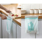 Aqua trash bag with cartoon face graphic, in use at a kitchen counter
