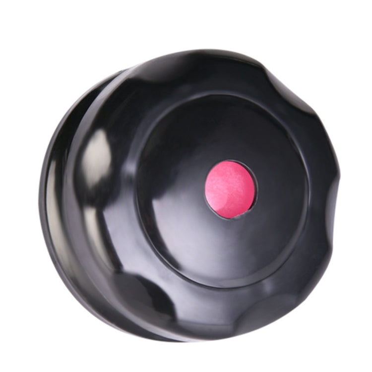 Black massage roller ball with pink center disc, top angled view.