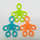 Set of silicone humanoid finger exercise pull rings in green, blue, and orange.