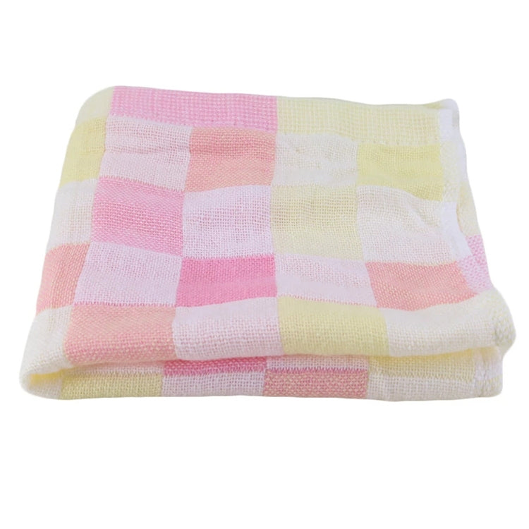 Folded checkered cotton bath towel in pink, cream, and pale yellow tones