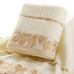 Cream bath towel detail: gold patterned hem with embroidered trim bands.