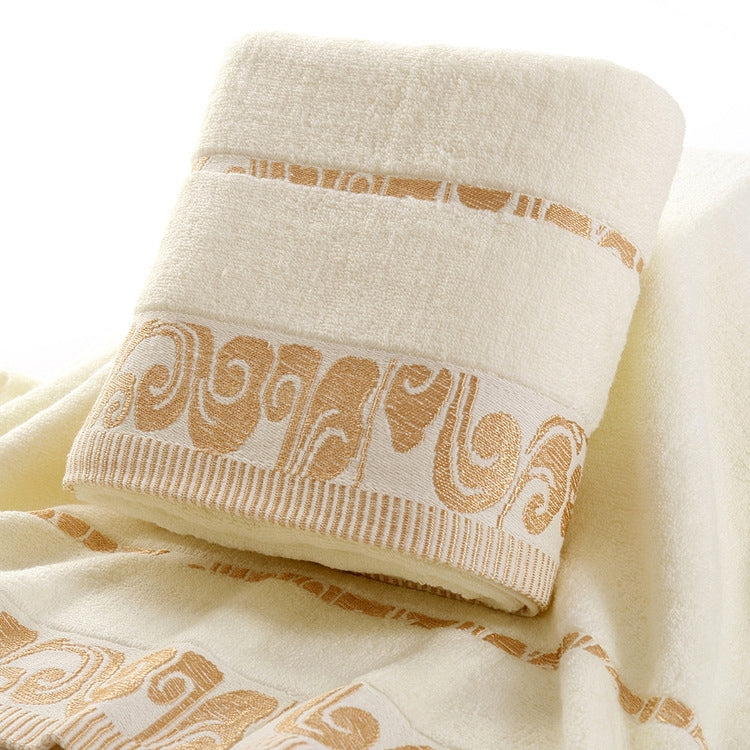Cream bath towel detail: gold patterned hem with embroidered trim bands.