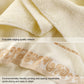 Cream cotton bath towel with gold patterned border and decorative hem stitching.