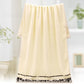 Cream cotton bath towel hanging with dark patterned border along the hem.