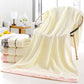 Cream cotton bath towel with pink ornate border trim, folded and draped.