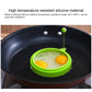 Green round silicone egg ring mold in skillet with two fried eggs.