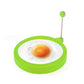 Green round silicone egg ring mold with metal handle, holding a fried egg center.