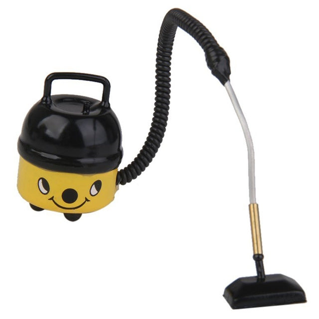 Yellow mini dollhouse vacuum cleaner with black canister, flexible hose, and flat floor brush