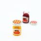 Mini orange jam jar with checkered lid; strawberry jar and spare lid partially visible