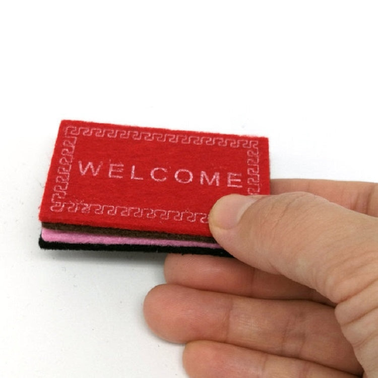 Red dollhouse welcome floor mat with 'WELCOME' text and Greek-key border