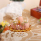 Mini doll house cosmetic set with pink bottles and gold tray on patterned table