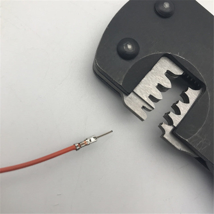 Crimping pliers close-up with wire and metal plug terminal in jaw