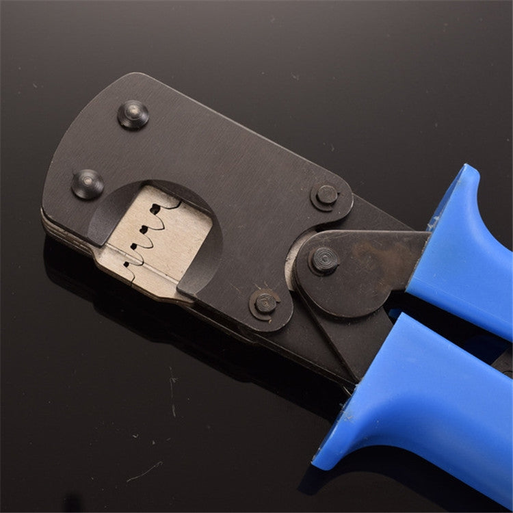 Crimping pliers with terminal inserted in metal die, blue handle visible