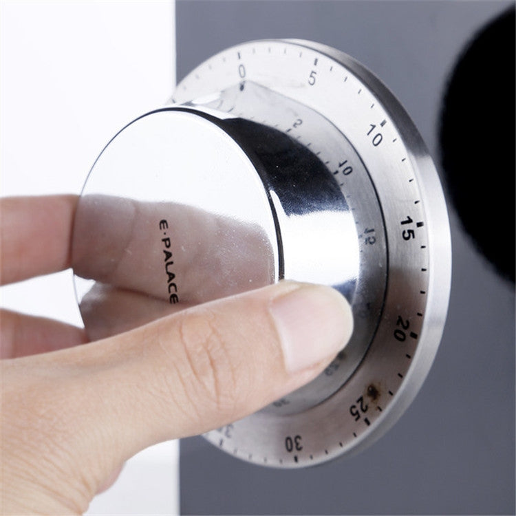 Stainless steel magnetic timer being turned, showing numbered countdown dial