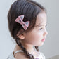 Girls bow hair clips in pink and gray on child with side braid