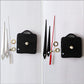 Black square clock mechanism with red and black hands and gold mounting rings