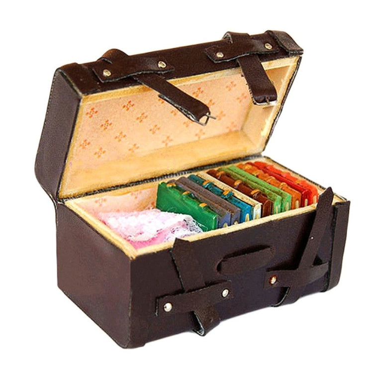 Miniature dark-brown suitcase open with colorful miniature items inside